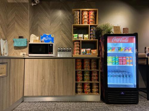 a cocacola soda machine sitting next to a counter at Cho Hotel 3 in Taipei