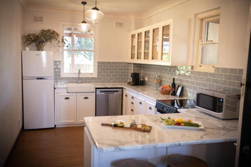 a kitchen with white appliances and a white refrigerator at Avoca House - Gorgeous Federation Home in Mudgee