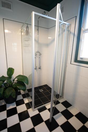 a shower with a glass door and a plant in a bathroom at Avoca House - Gorgeous Federation Home in Mudgee