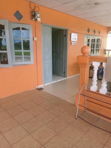 a room with orange walls and a door and a bench at Homestay Damai Sri Kota in Kepala Batas