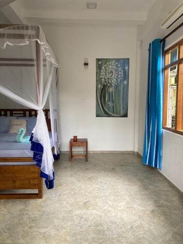 a bedroom with a canopy bed and a table at Garden Villa Talalla in Talalla