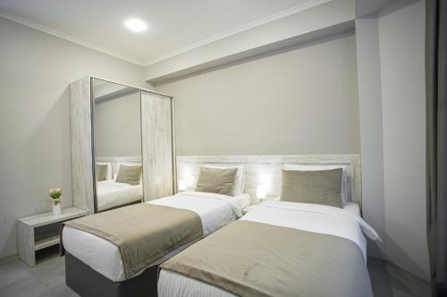 two beds in a room with a mirror at Koghbatsi Aparthotel in Yerevan
