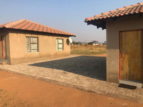 ein paar nebeneinander sitzende Gebäude in der Unterkunft Charli’s Lodge in Mpheleng