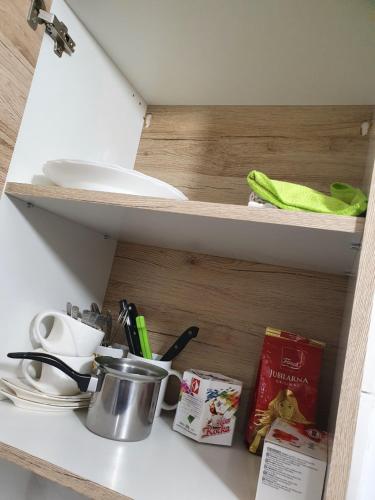 a kitchen shelf with a pot and dishes on it at Garsonjera u centru Prnjavor in Prnjavor