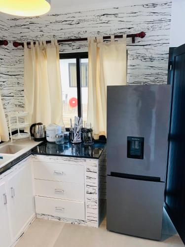 a kitchen with a stainless steel refrigerator and white cabinets at Horizon view in Victoria