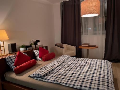 a bedroom with a bed with red pillows on it at Harfa Apartment 30 in Prague
