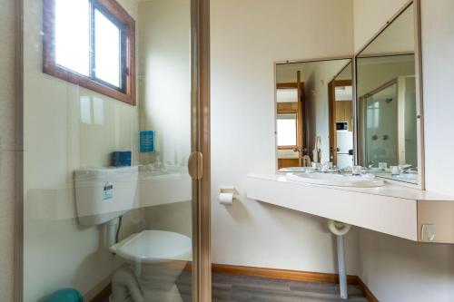 ein Badezimmer mit zwei Waschbecken, einem WC und einem Spiegel in der Unterkunft Deniliquin Riverside Caravan Park in Deniliquin