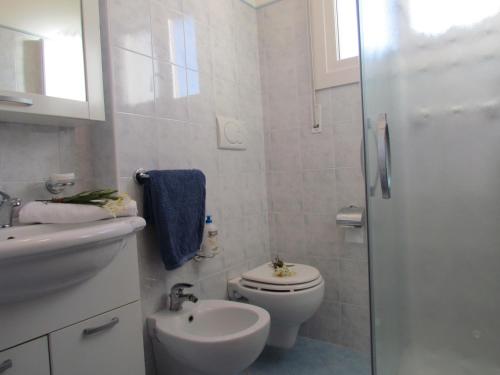 e bagno con servizi igienici, lavandino e doccia. di Luminous flat with frontal sea view - Beahost a Bibione