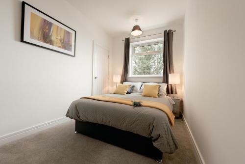 a bedroom with a bed and a window at Arlan Apartments Comfort and Ease, Hinckley in Hinckley