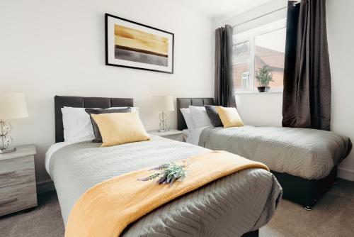 a bedroom with two beds and a window at Arlan Apartments Comfort and Ease, Hinckley in Hinckley