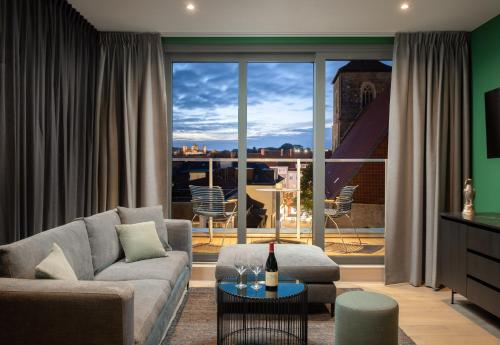 a living room with a couch and a table at Van der Valk Hotel Hildesheim in Hildesheim
