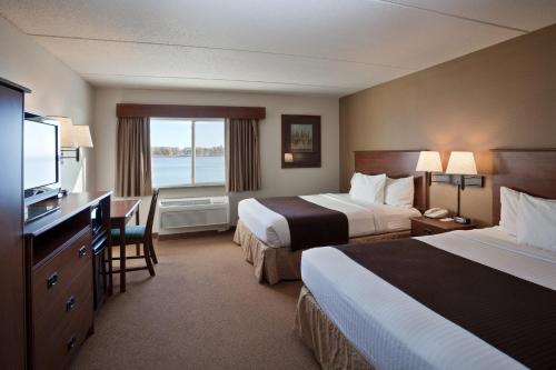 una camera d'albergo con due letti e una televisione di AmericInn by Wyndham Fort Pierre Conference Center a Fort Pierre