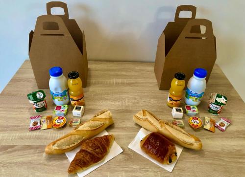 Una mesa con botellas de refresco y pan y botellas de leche. en Lou Meinado, un concept "comme à l'hôtel", en Saint-Martin-de-Crau