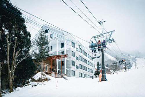a ski lift with people on it in the snow at コンドミニアム白馬五竜 in Hakuba