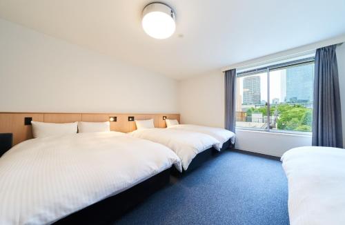 two beds in a room with a window at Rakuten STAY Osaka Station North Standard Fourth in Osaka