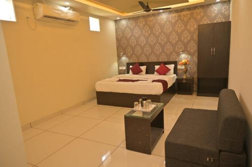 a hotel room with a bed and a couch at Kunwar Palace in Gorakhpur