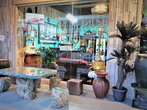 a store window with a table and potted plants at Blue Eyes Hotel in Kepala Batas
