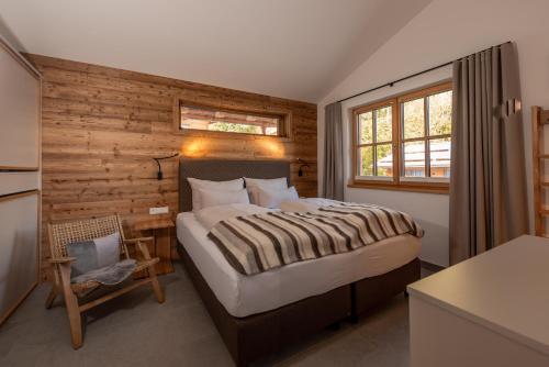 a bedroom with a large bed and a wooden wall at Luxury Chalets Gradenbach near Schladming in Haus im Ennstal