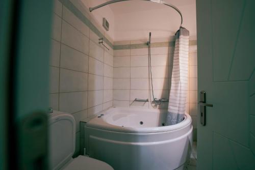 a bathroom with a tub and a toilet and a sink at Beautiful house in Aegina in Egina