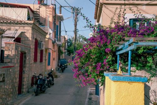a narrow street with purple flowers on the buildings at Beautiful house in Aegina in Aegina Town