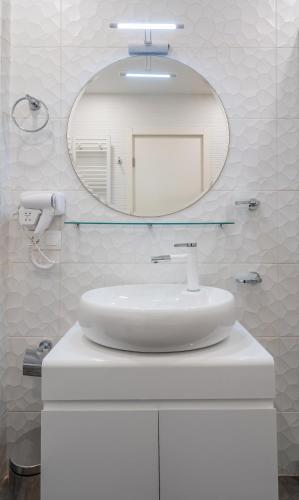 a white bathroom with a sink and a mirror at New Gudauri Neo Apartment 306 in Gudauri