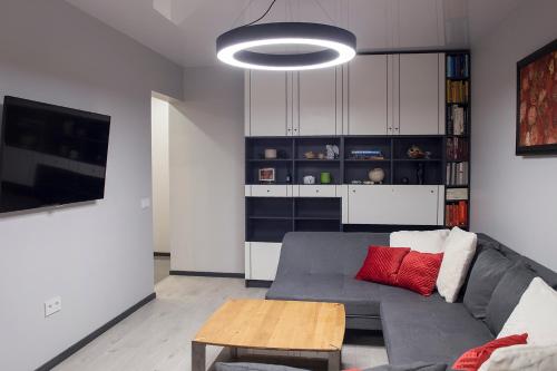 a living room with a gray couch and a table at Siauliai Apartments - Lieporiu in Šiauliai