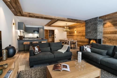 sala de estar con sofá y chimenea en Alaska Lodge by Alpine Residences en Val dʼIsère