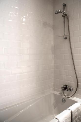 a white bath tub with a shower in a bathroom at Lousada Country Hotel in Lousada