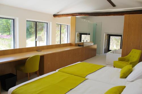 a bedroom with a large bed with a yellow blanket at Lousada Country Hotel in Lousada