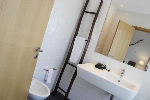 a bathroom with a sink and a toilet and a mirror at Lousada Country Hotel in Lousada