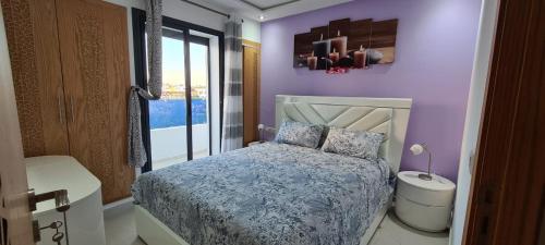 a bedroom with purple walls and a bed and a window at SuperAppart KENITRA in Kenitra