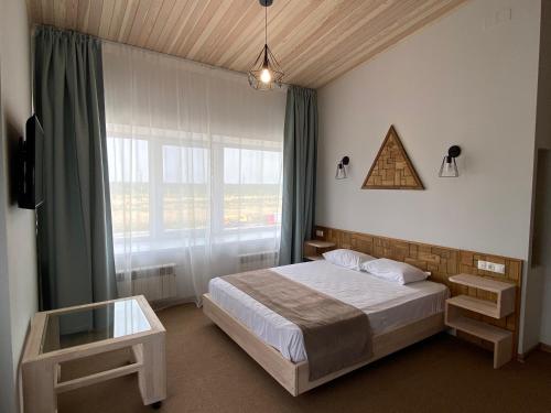 a bedroom with a bed and a large window at Irbis Hotel in Kazan