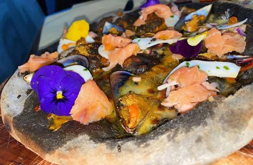 a pizza with a purple flower on top of it at Hotel Sagittario in San Sperate