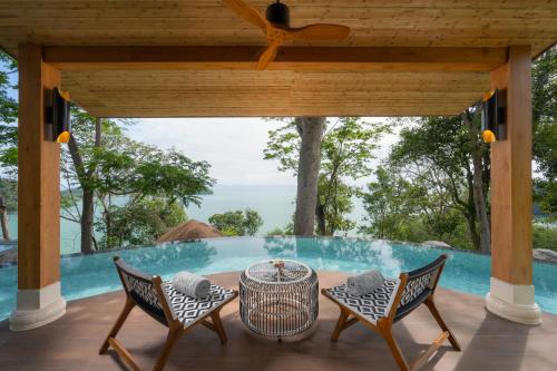 a patio with a table and chairs and a pool at Sinae Phuket - SHA Extra Plus in Phuket Town