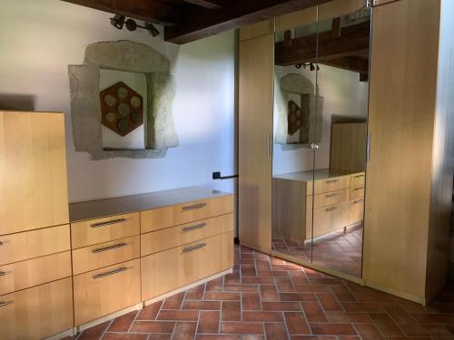 a kitchen with wooden cabinets and a large mirror at TowerHouse1517 in Serramazzoni