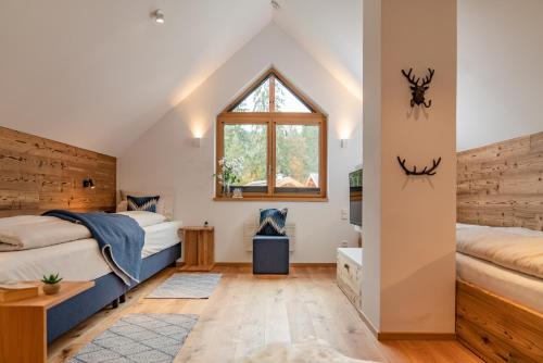 a bedroom with two beds and a window at Luxury Chalets Gradenbach near Schladming in Haus im Ennstal
