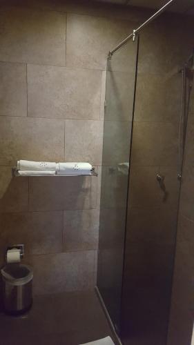 y baño con ducha de cristal y aseo. en Motel Nuevo Tijuana, en Ciudad de México