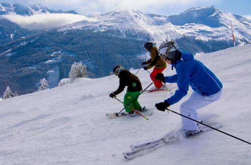 a group of people skiing down a snow covered mountain at MONDI Resort und Chalet Oberstaufen in Oberstaufen