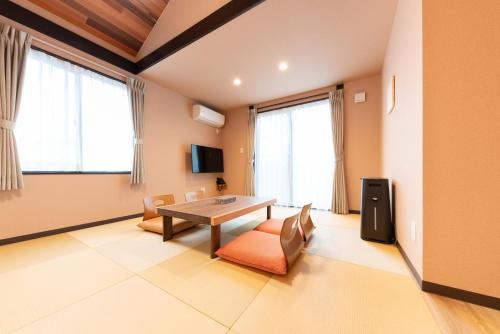 sala de estar con mesa, sillas y ventanas en スタジオーネ 箱根強羅 East - Stagione Hakone Gora East en Hakone