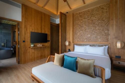 a bedroom with a bed and a couch and a tv at Sinae Phuket - SHA Extra Plus in Phuket Town