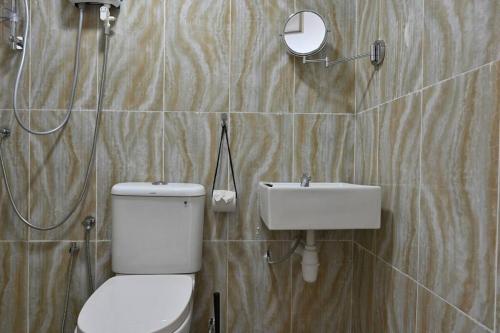 La salle de bains est pourvue de toilettes et d'un lavabo. dans l'établissement Full Moon Apartment (月满公寓）网红 airbnb, à Kuah