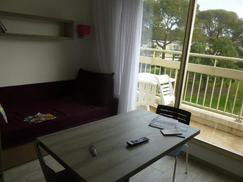 - un salon avec un canapé, une table et une fenêtre dans l'établissement La Corniche d'or à St Raphael, à Saint-Raphaël