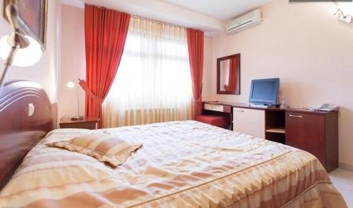 a bedroom with a large bed with a desk and a window at Villa Mia Suites in Ohrid