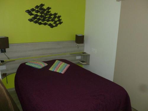 - une chambre avec un lit violet et 2 oreillers dans l'établissement La Corniche d'or à St Raphael, à Saint-Raphaël