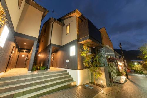 a house with stairs leading up to it at night at SYLA HOTEL 箱根強羅 East - SYLA HOTEL HAKONE GORA East in Hakone