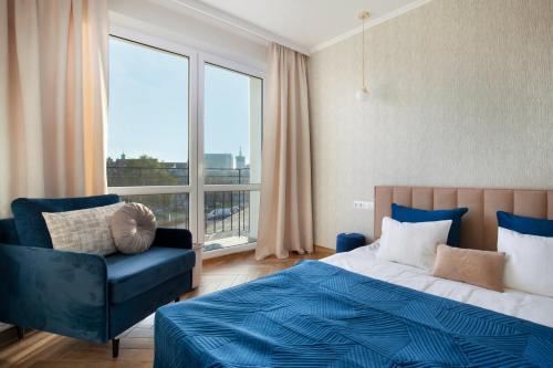 a bedroom with a bed and a chair and a window at Elite Apartments Old Town Center Premium in Gdańsk