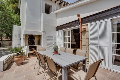 a patio with a table and chairs and a fireplace at Casa PADRI Font de Sa Cala by Mallorca Villa Selection in Capdepera
