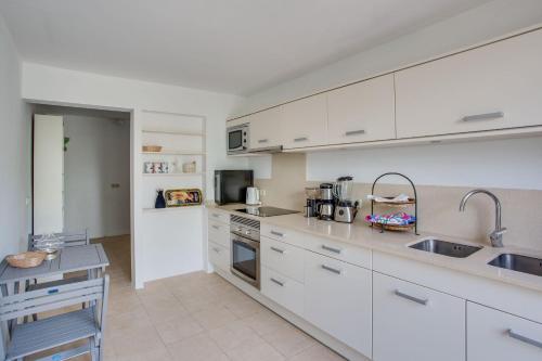 a kitchen with white cabinets and a sink at Casa PADRI Font de Sa Cala by Mallorca Villa Selection in Capdepera