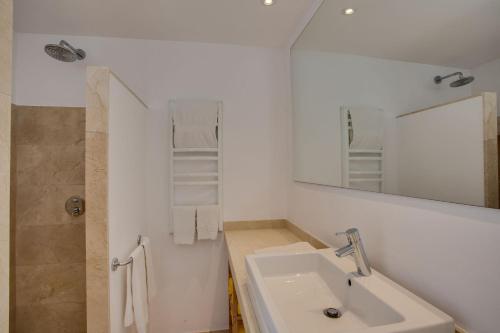 a white bathroom with a sink and a mirror at Casa PADRI Font de Sa Cala by Mallorca Villa Selection in Capdepera