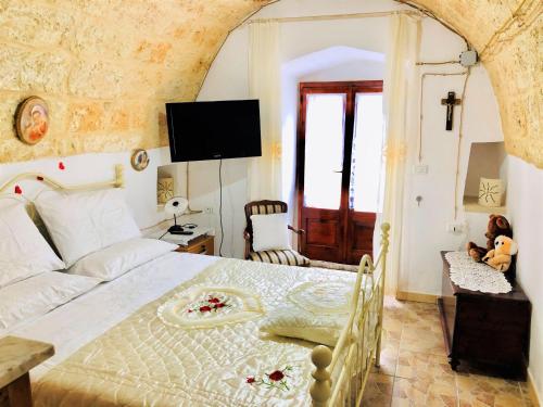 a bedroom with a bed and a tv on the wall at Il Giardino Degli Angeli in Presicce